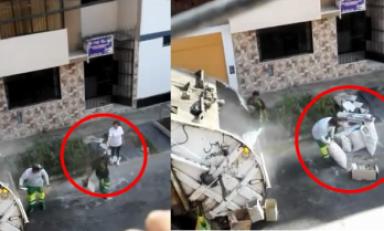 Trabajador del Segat recoge pesados sacos y luego recibe algo de una vecina. Foto: Trujillo en Línea